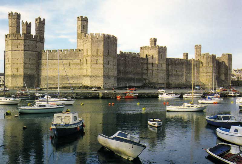 Les
                    murs imposants du château de Caernarfon au dessus du
                    petit port