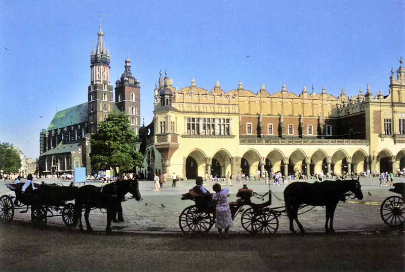 La Grande Place du Marché de Krakow, avec la Halle
              aux Draps et les deux tours dissymétriques de l'église
              Notre Dame