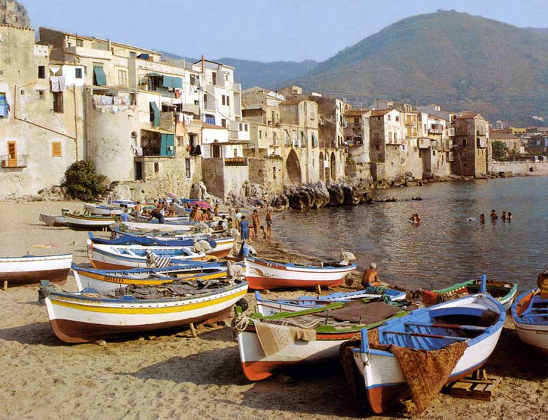 Cefalu : barques de
      pêche échouées sur la plage devant la vieille ville