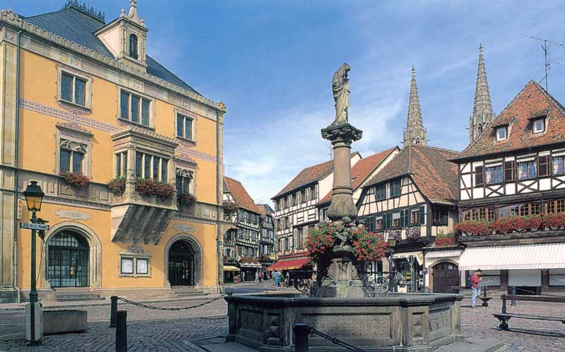 Obernai : la Place du Marché, l'Hôtel de Ville (XVème
              et XVIème), et la fontaine (1904) portant la statue de
              Sainte Odile