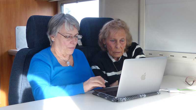 Thérèse et Monique regardent des photos anciennes
                  sur l'ordinateur dans L'Exsis