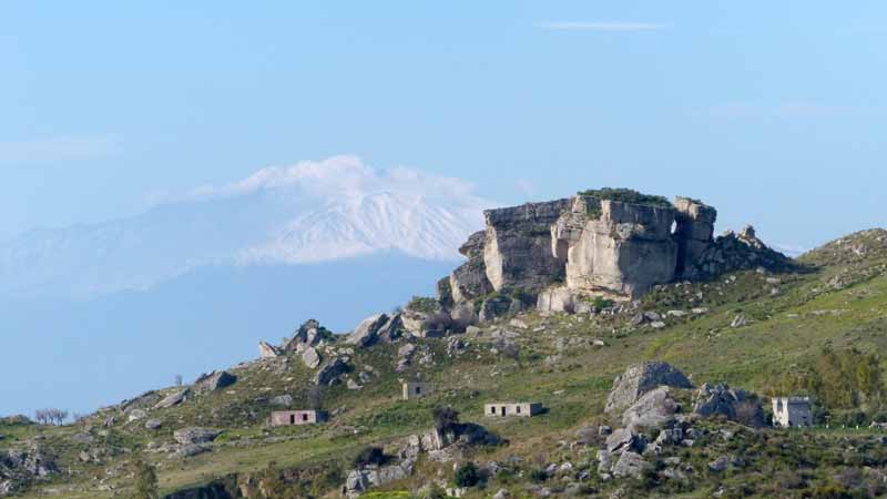 Pentidattilo : les rochers ruiniformes et l'Etna
            enneigé