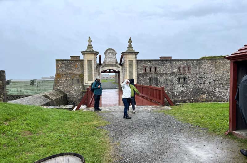 Devant la Porte Dauphine donnant accès à la
                  forteresse de Louisbourg